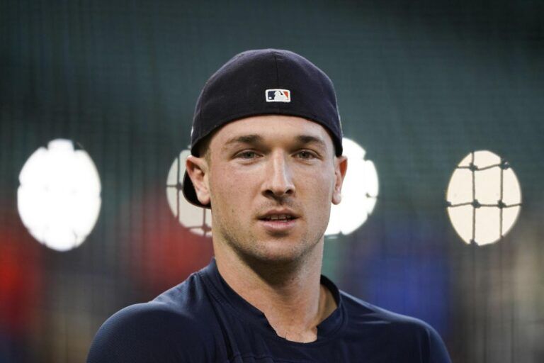 Alex Bregman, the Houston Astros' third baseman, is pictured before a 2024 MLB game, wearing the team's hat and black shirt. Reports indicate that the New York Yankees are interested in signing Bregman this offseason to strengthen their infield and lineup.