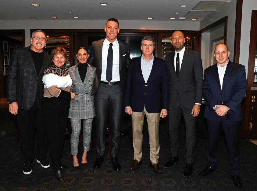 Aaron Judge y su familia posan con el propietario de los Yankees, Hal Steinbrenner, y Derek Jeter cuando firmó el contrato de 360 millones de dólares en 2023.